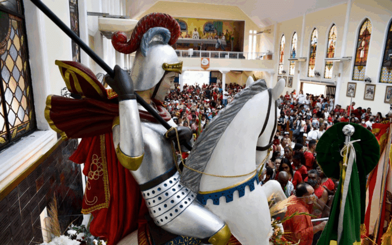 Estátua de cavaleiro em igreja cheia de pessoas.