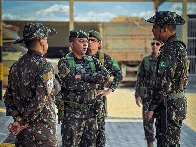 Militares brasileiros em uniforme conversando ao ar livre.