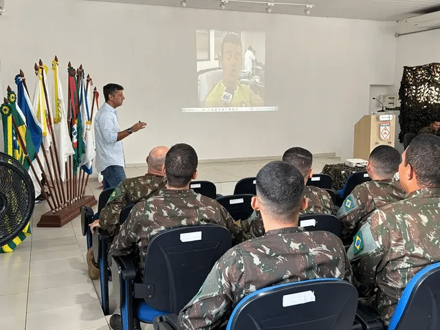 Aula de treinamento militar com apresentação em projetor.