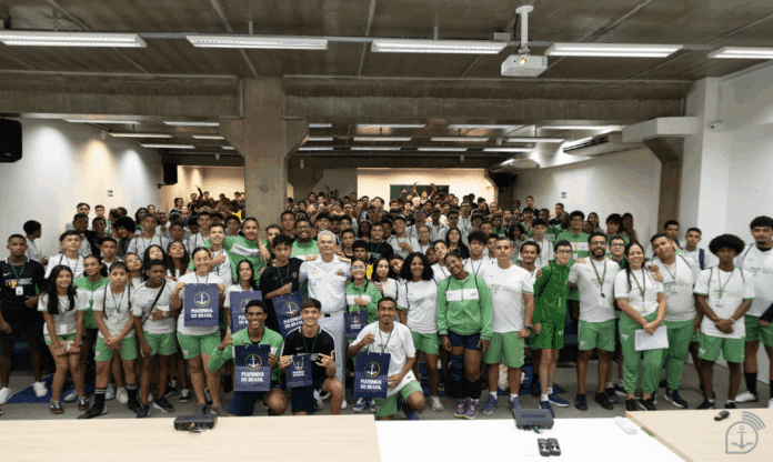 Grupo de pessoas uniformizadas em auditório.