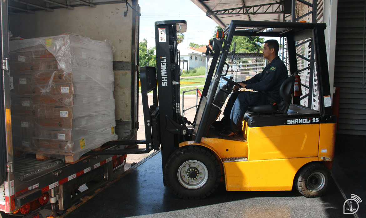 Empilhadeira carregando pallets em um caminhão.