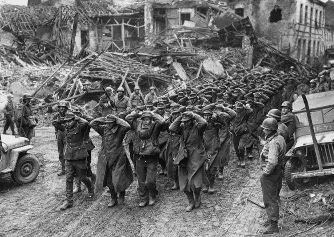 Soldados rendidos caminhando em cidade destruída, Segunda Guerra.