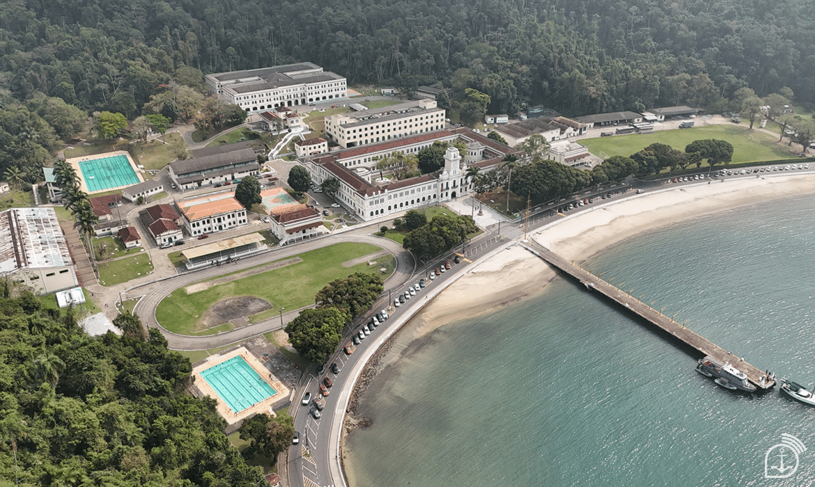 Vista aérea de academia militar na praia e mata.