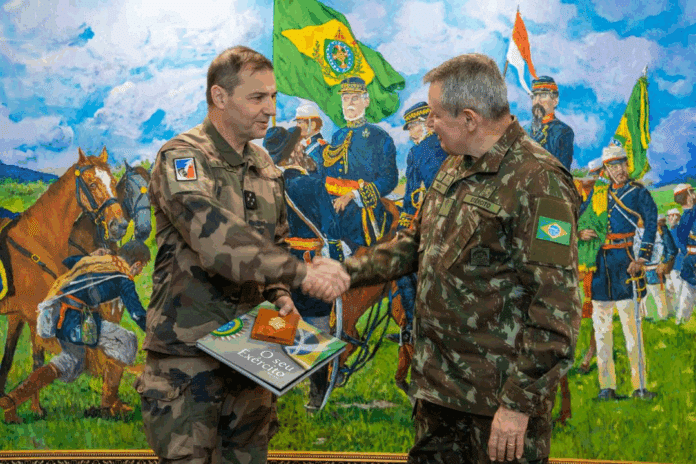 Oficiais militares apertam as mãos diante de pintura histórica.