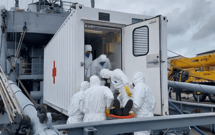 Resgate médico com trajes de proteção em navio.