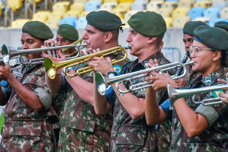 Fanfare militar tocando trompetes em formação.