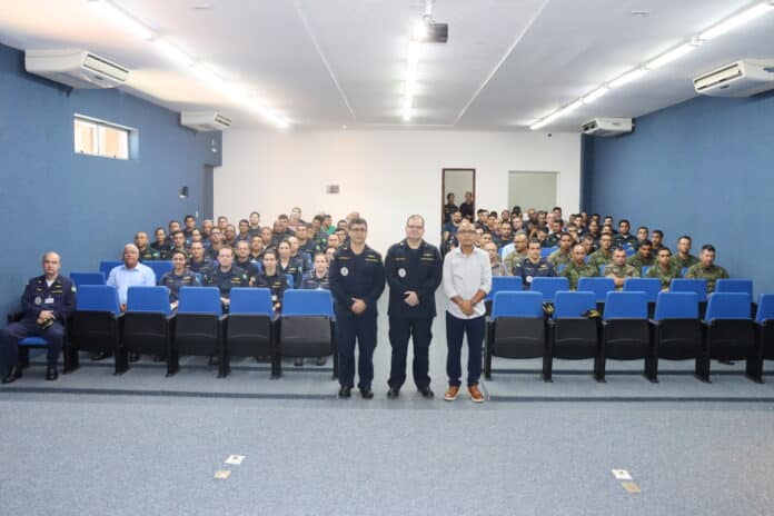Pessoas em auditório durante evento ou palestra militar.