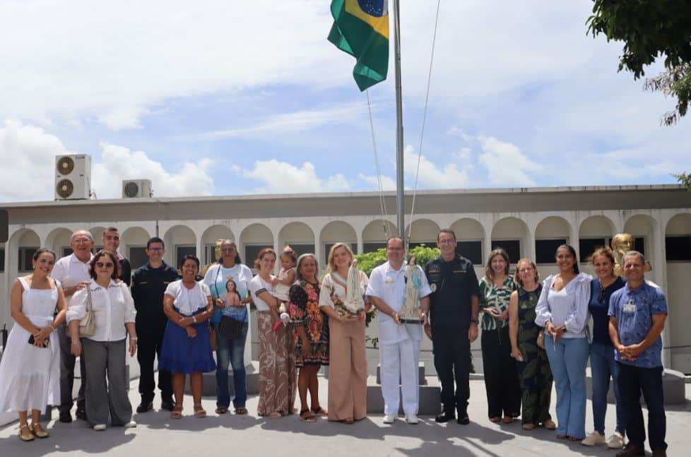 Grupo com bandeira do Brasil ao fundo.