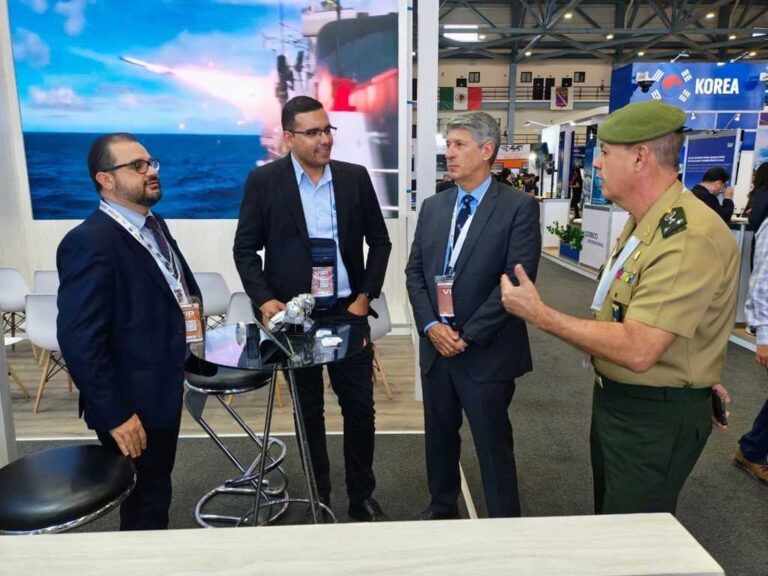 Pessoas conversando em evento de segurança e defesa.