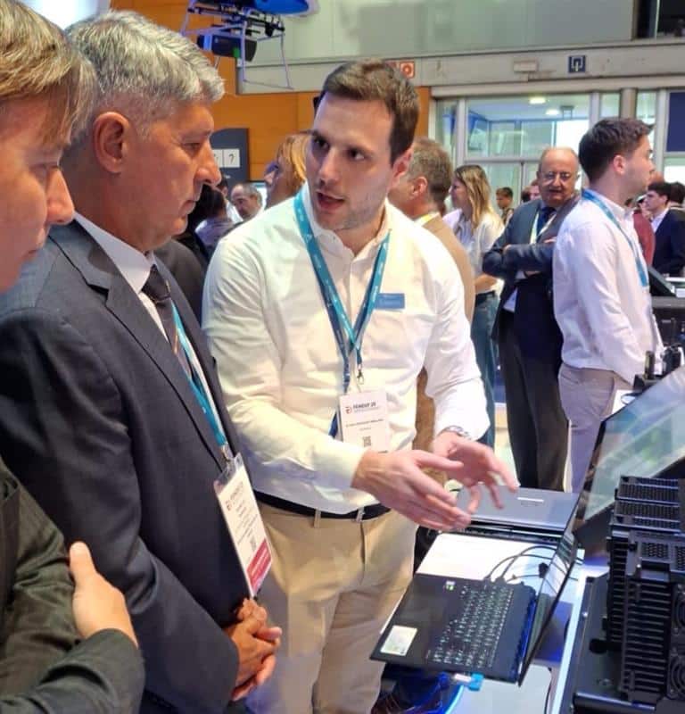 Homem explicando tecnologia em feira de negócios.