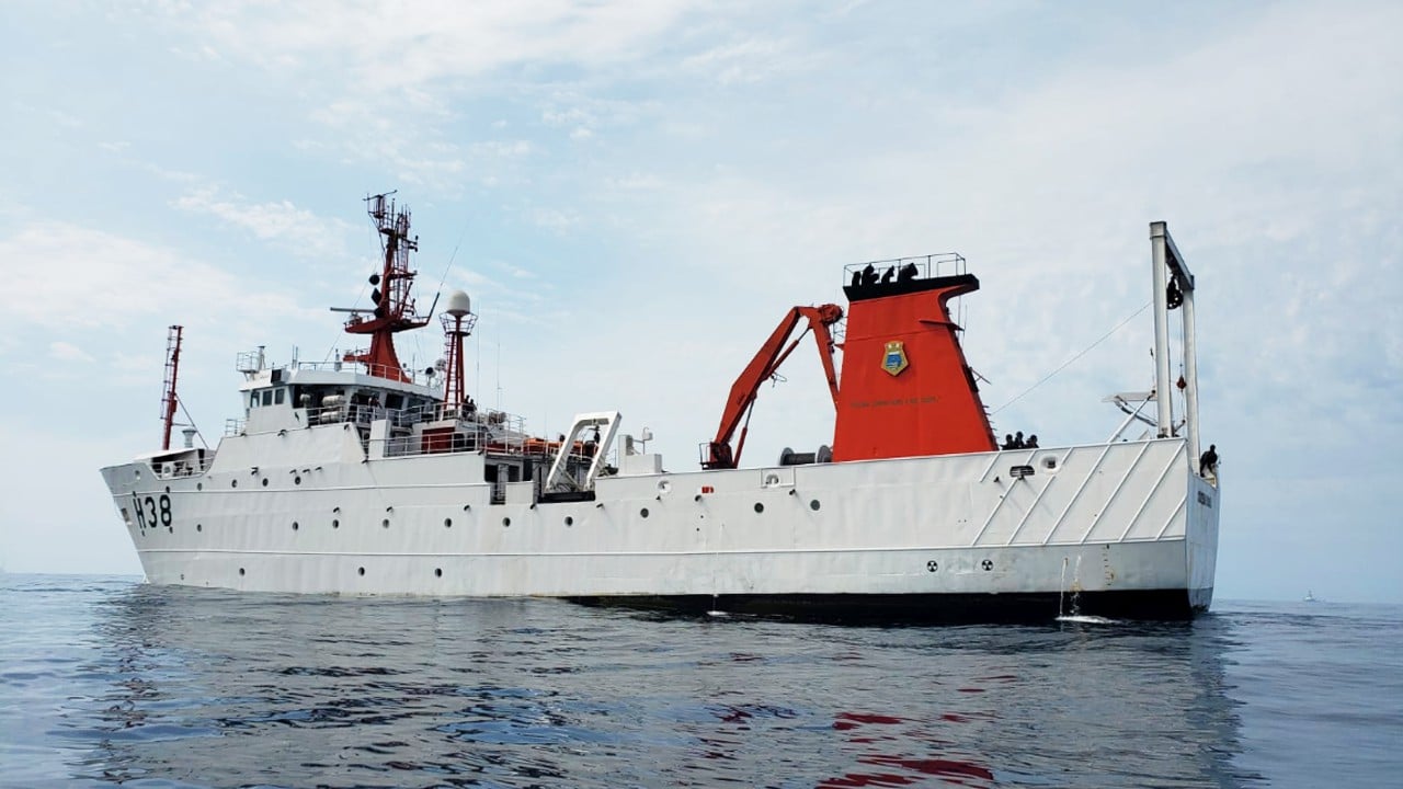 Navio de pesquisa no oceano, equipagem visível.