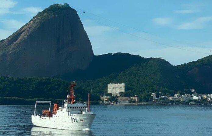 Navio no mar com Pão de Açúcar ao fundo.