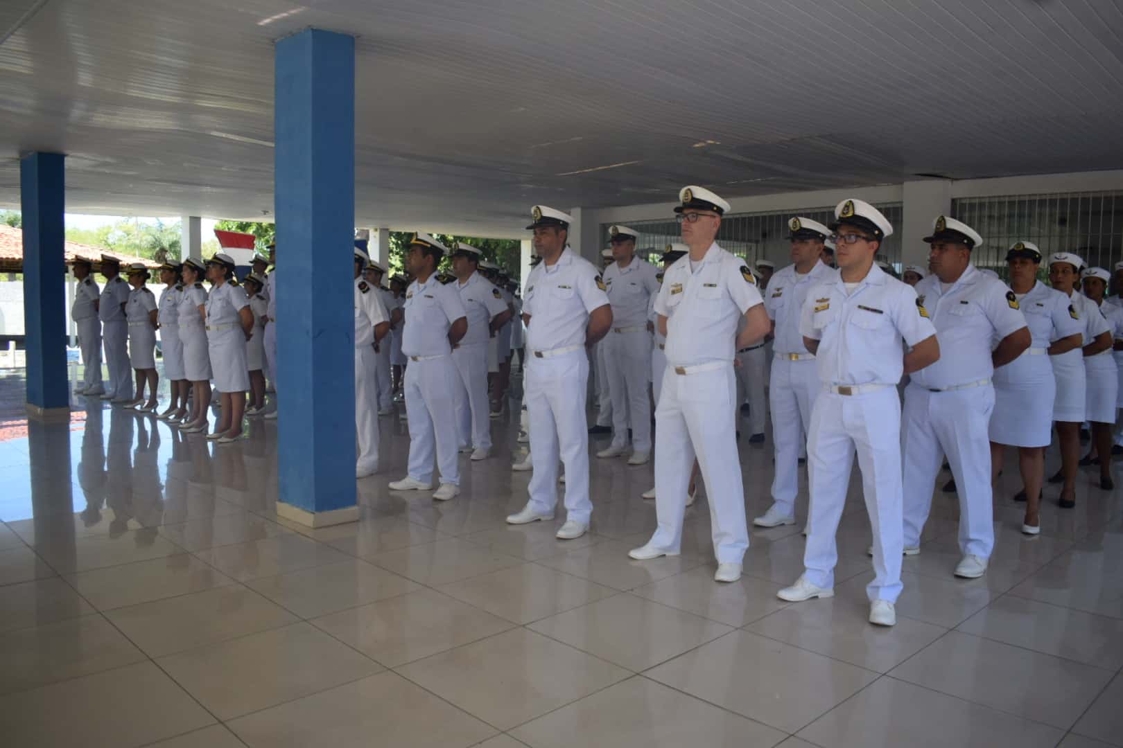 Cerimônia oficial com militares em uniforme branco.