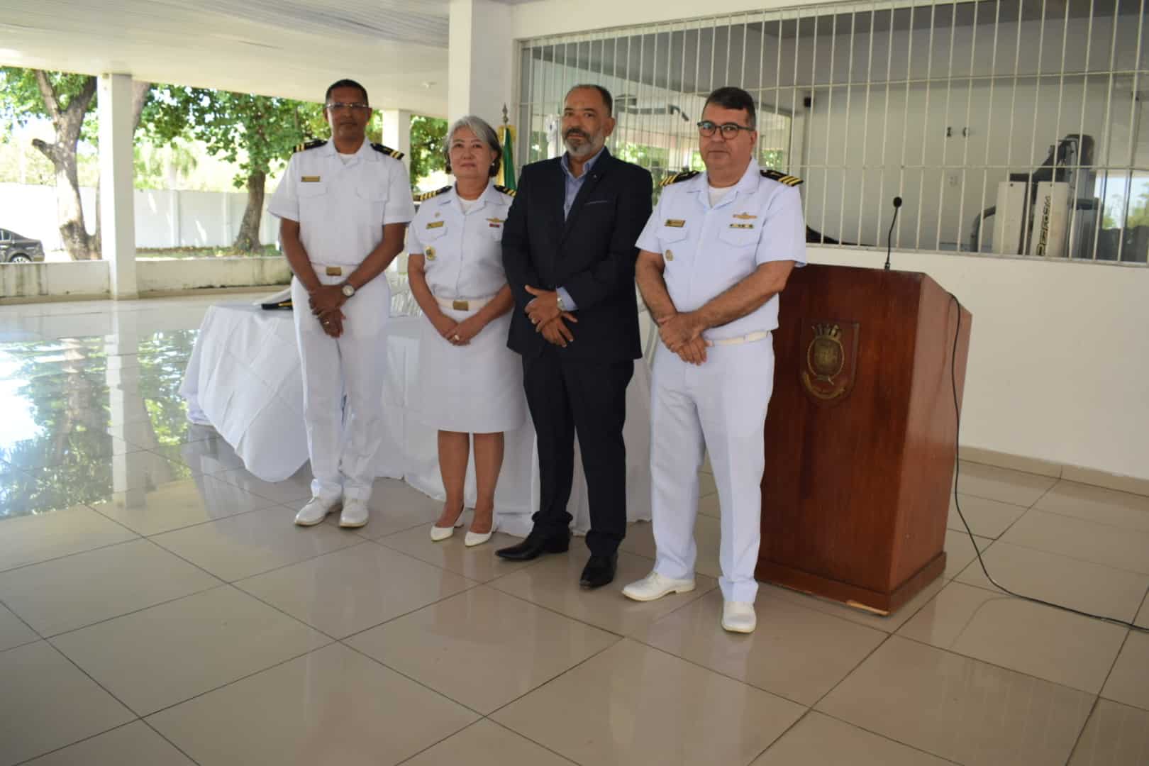 Oficiais navais e homem em pé em cerimônia