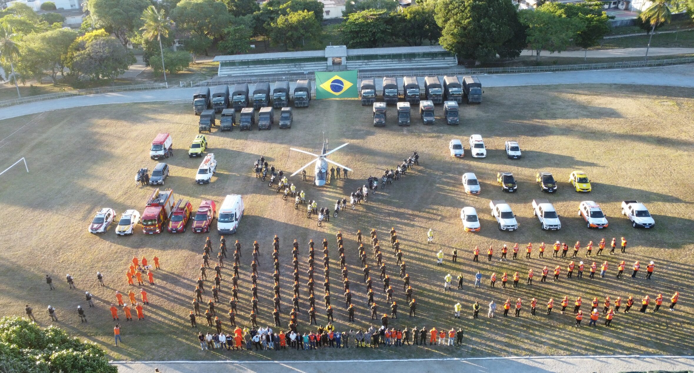 Simulação de operação militar com veículos e helicóptero.