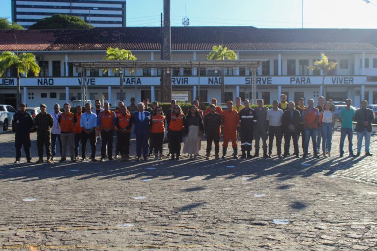 Grupo de pessoas em frente a prédio militar.
