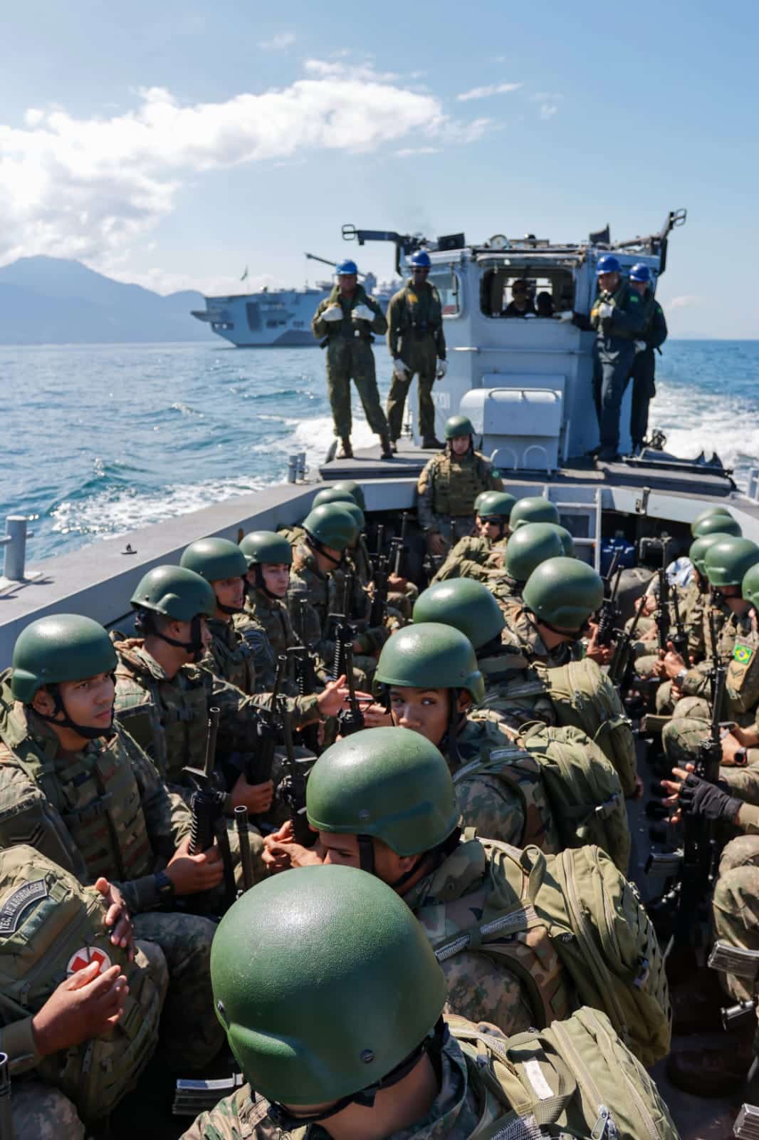 Soldados em barco militar no mar.