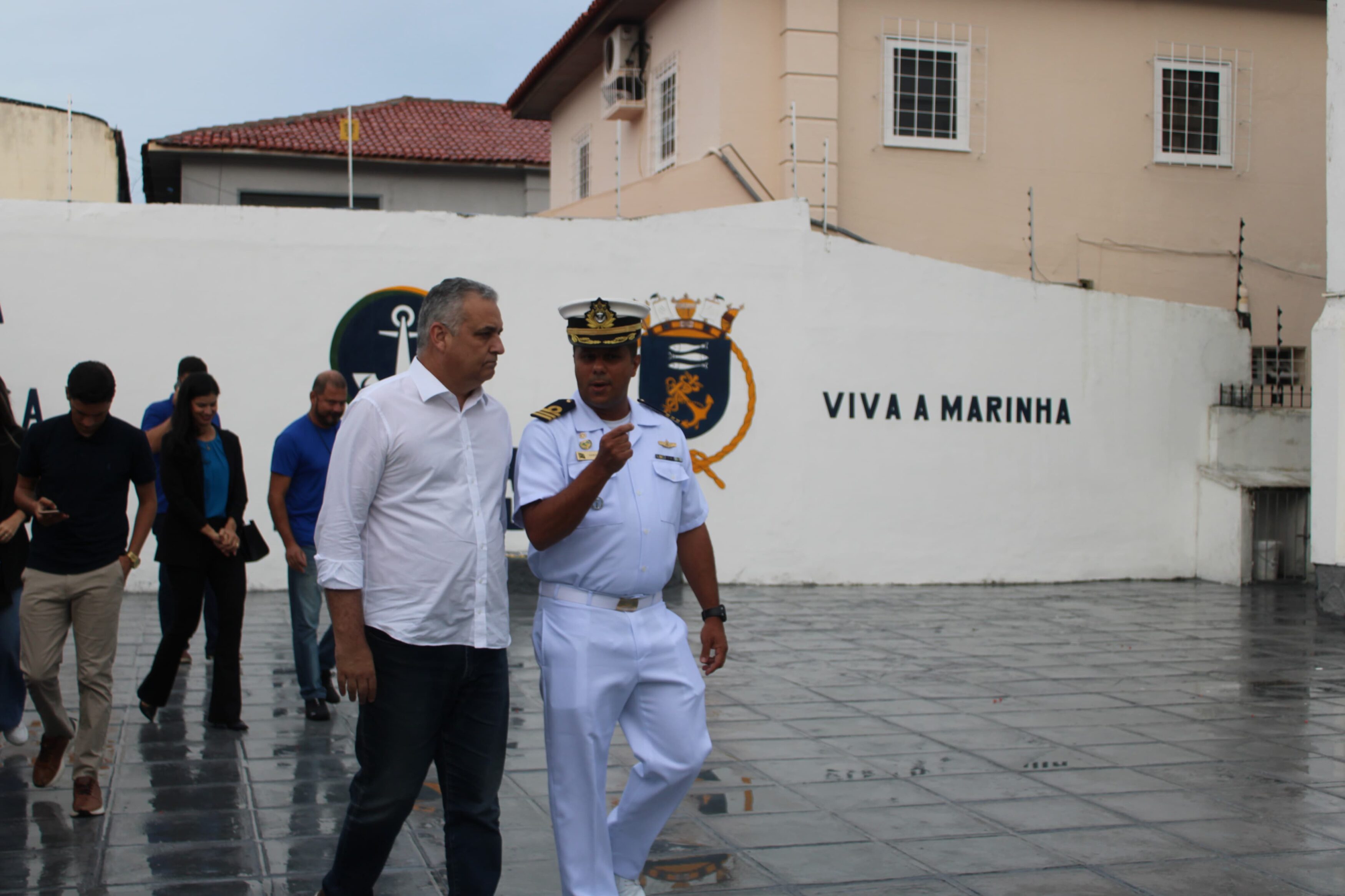 Oficiais em frente ao mural da Marinha