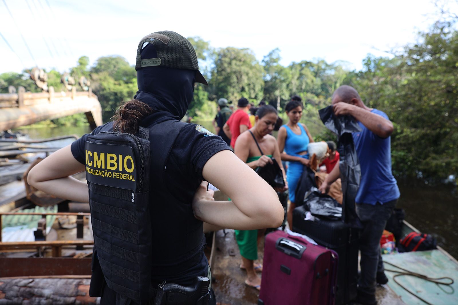 Fiscalização ambiental com grupo em barco na floresta.