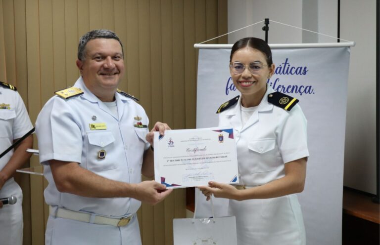 Pessoas em uniforme naval entregando certificado.