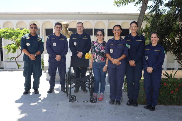 Grupo uniformizado com cadeira de rodas ao centro.