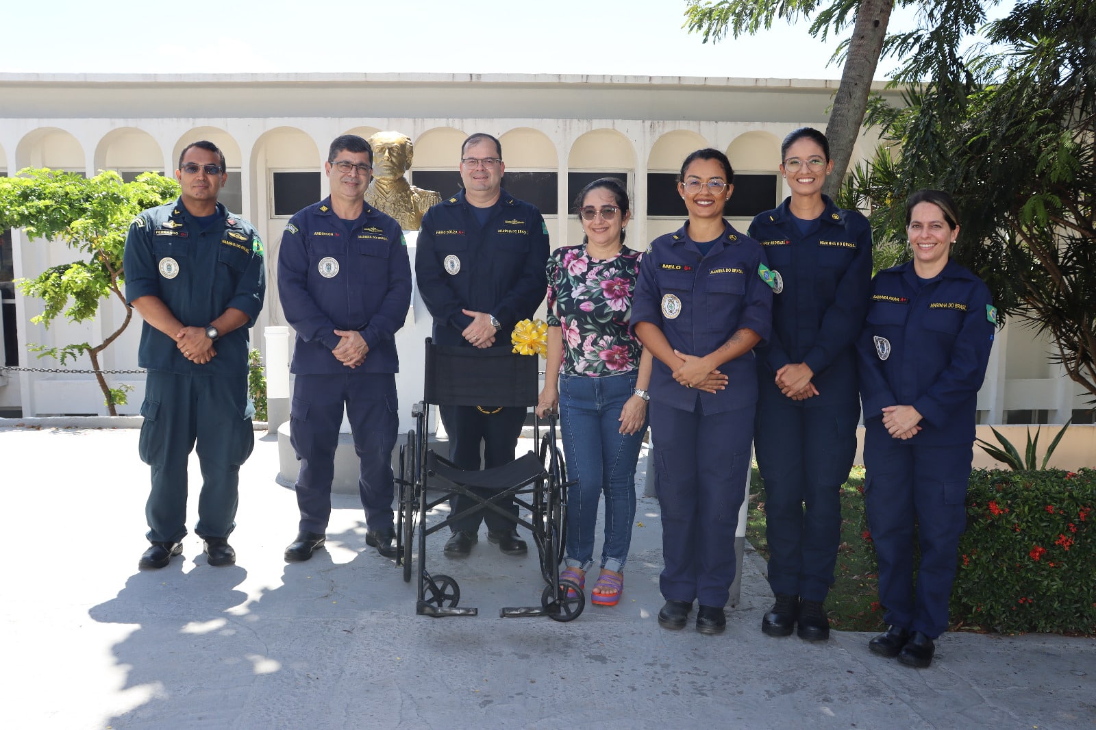 Grupo uniformizado com cadeira de rodas ao centro.