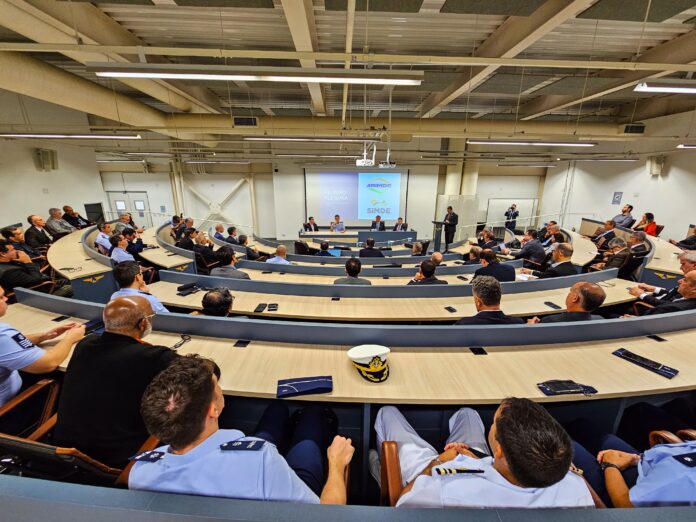 Reunião em auditório com oficiais militares e civis.