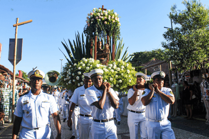 Procissão de marinheiros carregando andor com flores