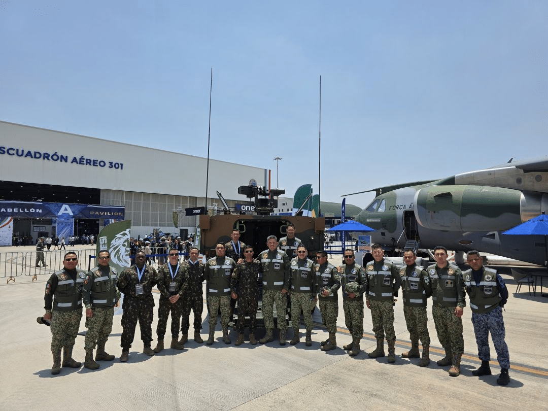 Militares em frente ao hangar e aeronave militar.