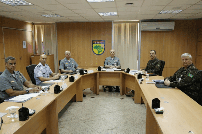 Reunião de oficiais militares em sala de conferências.
