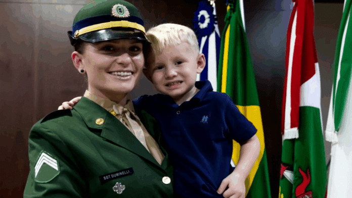 Soldado sorrindo com criança em frente a bandeiras