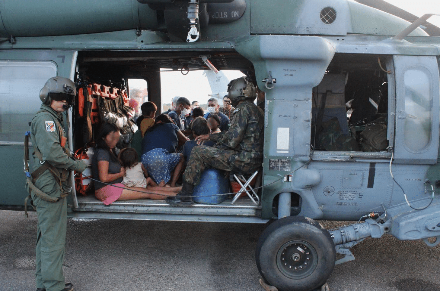 Pessoas sendo resgatadas por helicóptero militar.