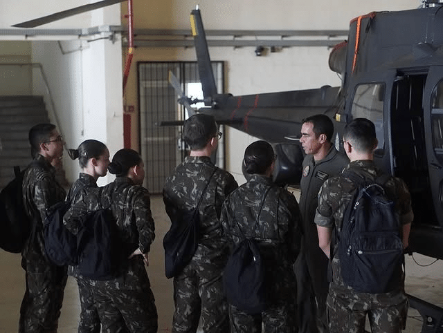 Soldados recebem instruções sobre helicóptero militar.