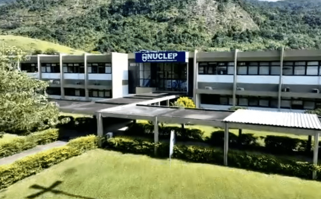 Fachada do prédio da NUCLEP com montanha ao fundo.