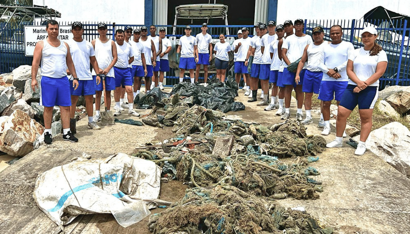 Grupo da Marinha brasileira limpa praia.