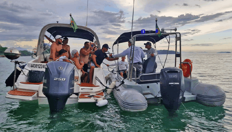 Pessoas em barcos no mar, bandeira do Brasil.