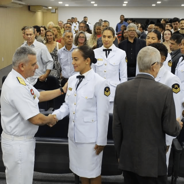 Cerimônia militar com oficiais cumprimentando convidados.