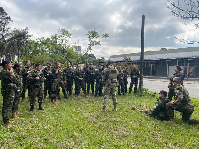 Soldados em treinamento ao ar livre, discutindo estratégias.
