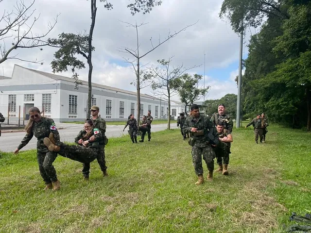 Soldados em exercício de treinamento militar ao ar livre.