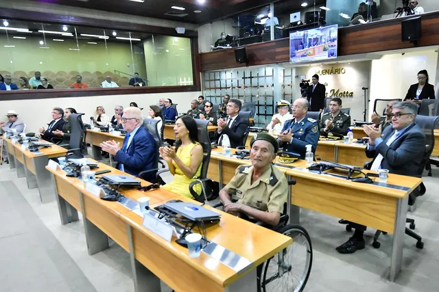 Pessoas aplaudindo em sessão legislativa pública.
