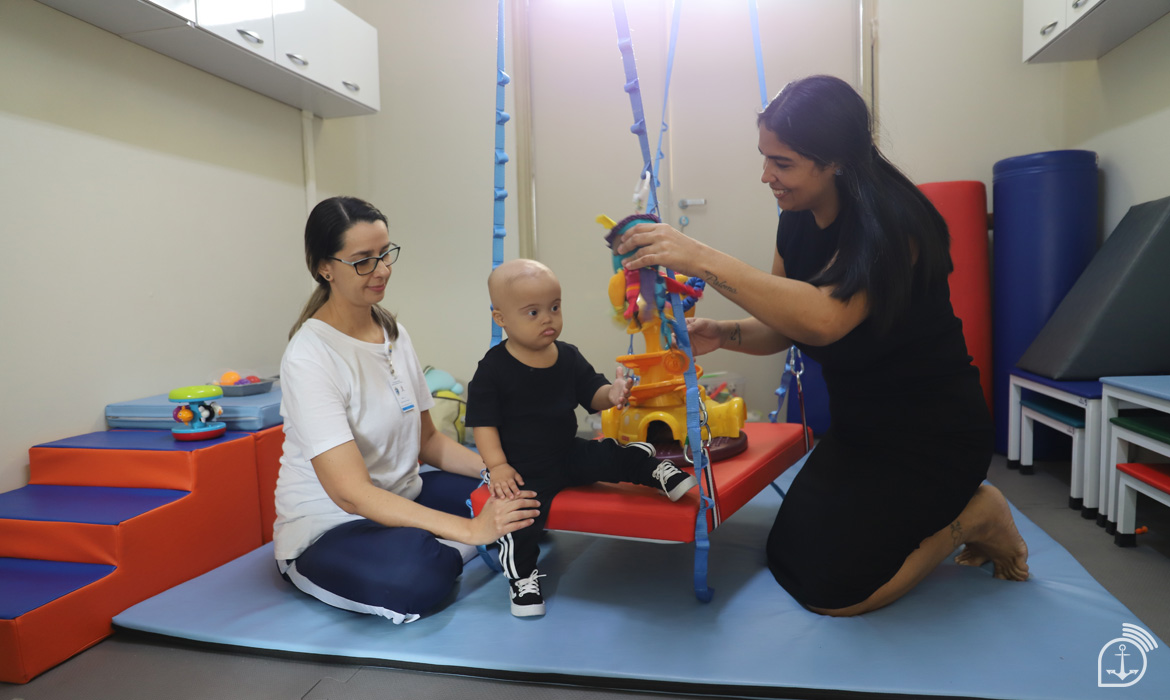 Terapia infantil com criança e duas terapeutas.