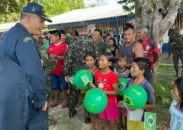 Crianças com balões brasileiros em evento militar.