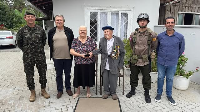 Grupo de pessoas em frente a uma casa.