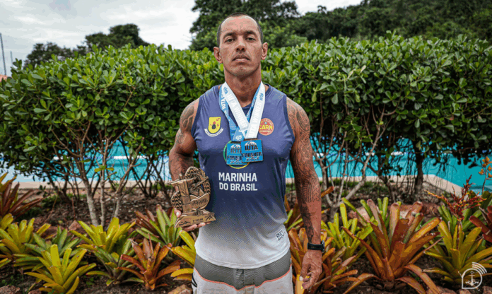 Atleta com medalhas e troféu da Marinha do Brasil.