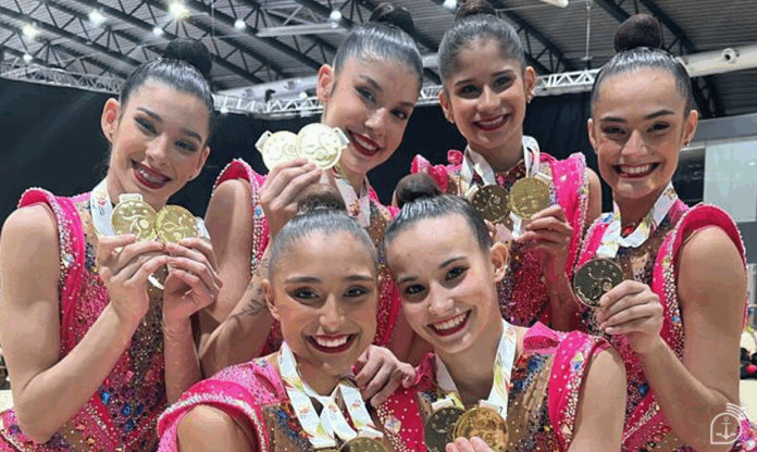 Equipe de ginástica celebra com medalhas douradas.