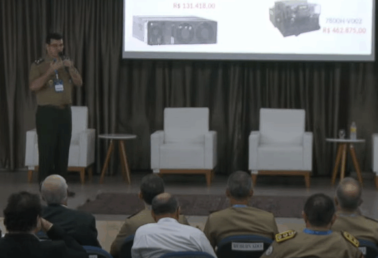 Palestra militar com assentos vazios e equipamentos no slide.