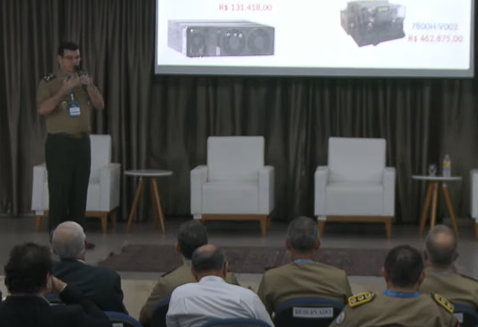 Palestra militar com assentos vazios e equipamentos no slide.