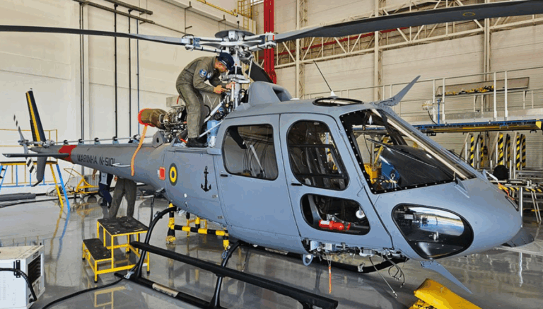 Manutenção em helicóptero militar em hangar.