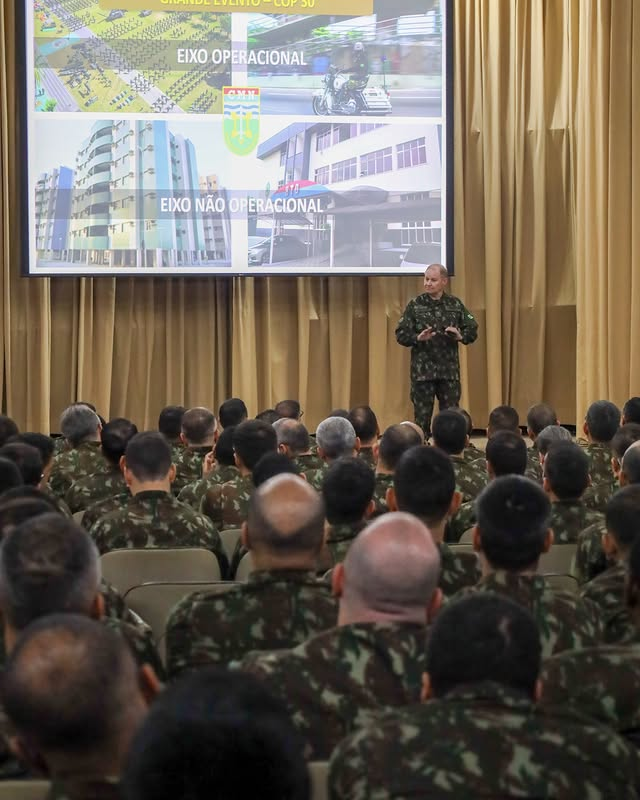 Apresentação militar com projeção de slides.