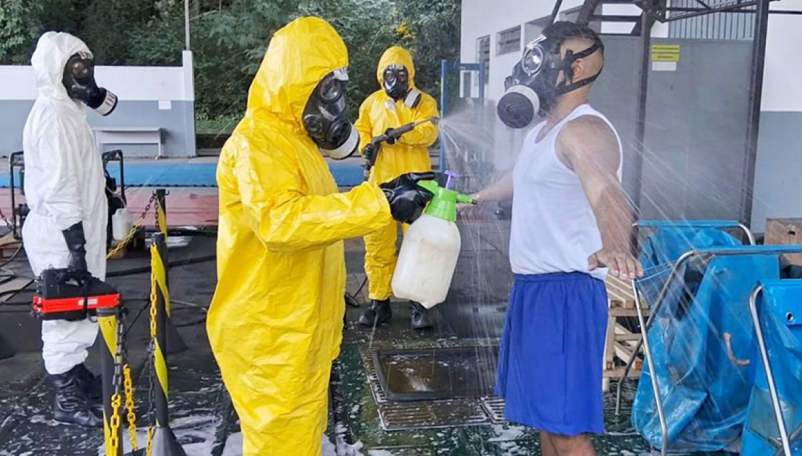 Descontaminação com trajes de proteção e máscaras.
